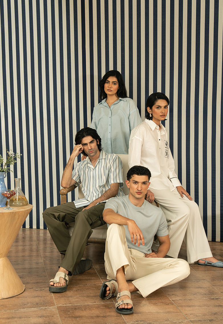 Four people posing in a room with a striped wall.